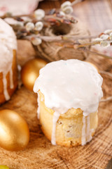 A table decorated for the holiday. Homemade delicious cake in sugar icing and dyed eggs. Easter cake and golden eggs on festive Easter table. Close-up. A festive tea party for Easter.