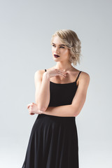 Fototapeta premium attractive blonde girl posing in elegant black dress, isolated on grey