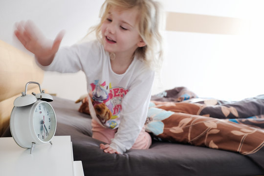 kleines m&auml;dchen schl&auml;gt auf wecker