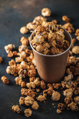 Diverse Popcorn in a paper cup against a dark background. Top view