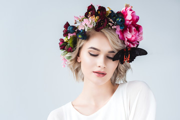 beautiful tender girl posing in floral wreath with butterfly, isolated on grey