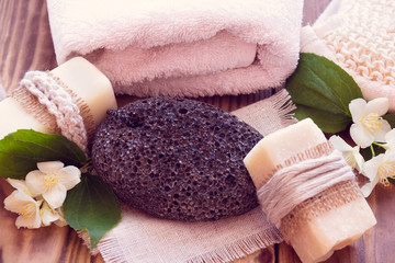 Two pieces of dry soap with a jasmine, towel, pumice and a bast