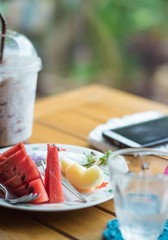 Slices of fresh Watermelon fruit with slices apple on white plate on wooden table