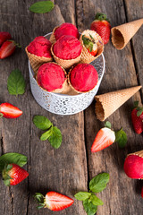 Ice cream, Strawberry scoop in cone on wooden table. 