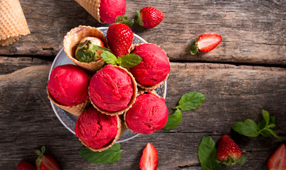 Ice cream, Strawberry scoop in cone on wooden table. 