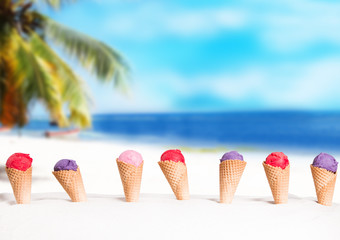 Ice cream. Blueberry and Strawberry scoop in cone on sand beach © verca