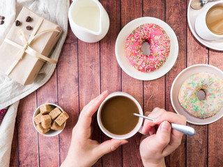 Donuts and coffee on wooden table. Top view with copy space