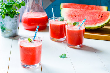 Fresh watermelon smoothies, glasses is standing on wooden table.
