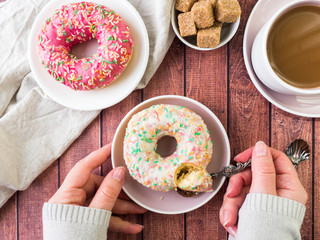 Donuts and coffee on wooden table. Top view with copy space