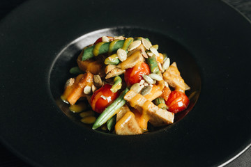 Fresh healthy dinner with seeds and vegetables on black plate