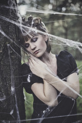 The young model is posing as a fairy in a spiderweb