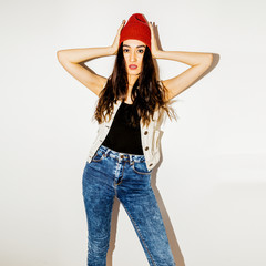 Brunette Pretty girl in fashion beanie cap and jeans. Urban casual style
