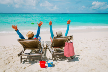 happy parent relax while kids swim on beach