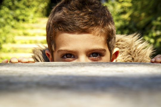 Boy Peeking Over A Table