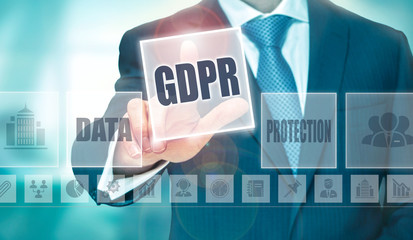 A businessman's hand selecting a GDPR concept button on a futuristic computer screen.
