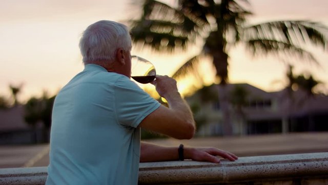 Healthy Senior Man Sips Wine And Watches The Sunset From A Balcony In Florida - Shot On Red Scarlet-W Dragon In 4K/ Slow Motion