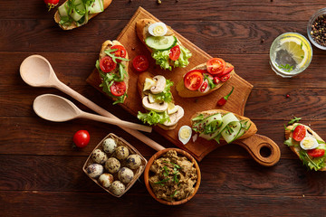 Breakfast still life with sandwiches, quail eggs, spicies, fresh vegetables and chicken paste, selective focus