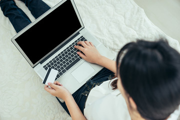 Naklejka premium Młoda Azjatka jest freelancerką i prowadzi prywatną firmę w domowym biurze, pracując z laptopem, kawą, marketingiem online. Młoda kobieta uruchamia swój biznes MŚP.