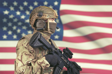 Obraz premium USA male soldier with machine gun in hand and American flag on background