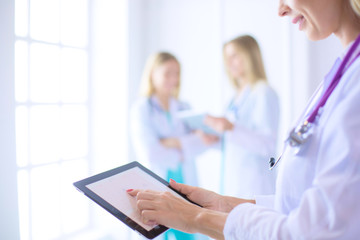 portrait of a young female doctor, with aipads in hand, in a medical office