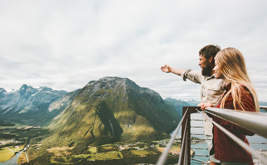 Fototapeta na wymiar Couple travelers enjoying mountains landscape love and Travel happy emotions Lifestyle adventure vacations concept traveling together in Norway Rampestreken viewpoint