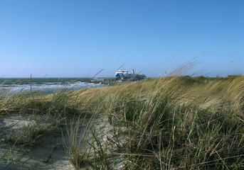 Laesoe / Denmark: View from the dunes to a RoRo ferry at the ferry terminal in Vesteroe Havn