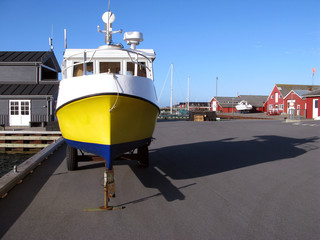 Laesoe / Denmark: Small fishing boat with yellow hull on a trailer on the quay in Vesteroe Havn © torstengrieger