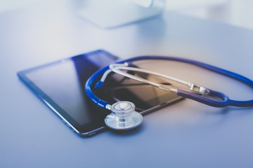 Medical equipment: blue stethoscope and tablet on white background. Medical equipment