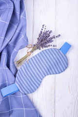 Healthy sleep concept. Sleep mask and lavender flowers on a light wooden background. Top view, free...