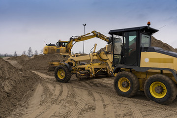 The excavator and bulldozer are preparing sand for loading