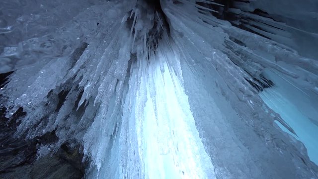 Dolly Close Around ice shiny brilliant transparent sharp hanging lump texture ceiling cave rock inside unique. Dangerous long Mystic impress. Winter frost Environment. Russia Baikal Arctic. Gimbal 