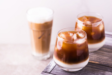 Iced coffee in glasses with milk. Black background