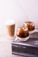 Iced coffee in glasses with milk. Black background