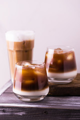 Iced coffee in glasses with milk. Black background