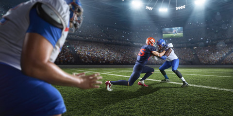 Obraz na płótnie Canvas American football players preforms an action play in professional sport stadium