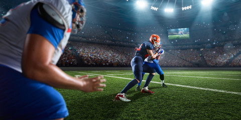 Naklejka premium American football players preforms an action play in professional sport stadium