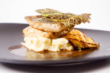 Sturgeon, savoy cabbage, mushrooms broth, mashed potato with butter on a plate on a white background