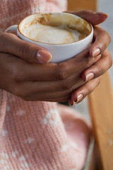 Two hands holding a hot cup of  Tea or Coffee