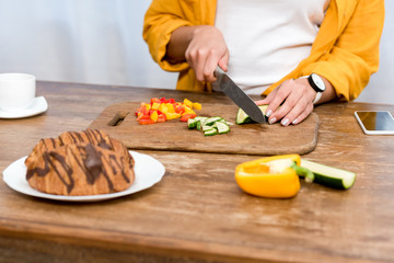 cropped shot of woman slicing vegetables for salad
