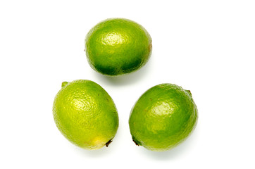 three green limes on a white background