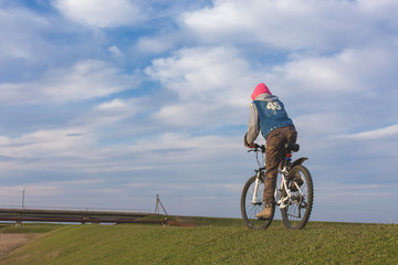 Mountain biker riding on green grass, spring bike ride