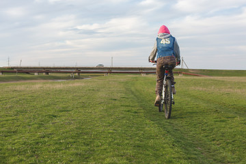 Mountain biker riding on green grass, spring bike ride