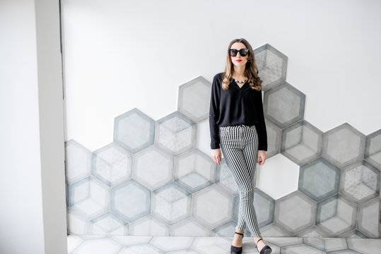 Portrait of a business woman standing on the beautiful tiled wall background indoors