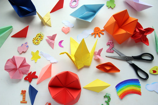  Multicolored Origami and paper on  a white table.