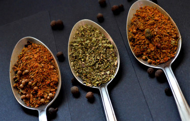Various spices spoons on stone table. Top view with space for your text