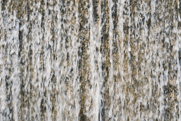 Waterfall curtain splash in gardren pool for relax and refreshing Travel in sunny day. Water fall background