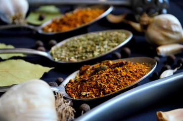 Various spices spoons on stone table. Top view with space for your text