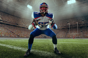 American football player performs an action play on professional sport stadium