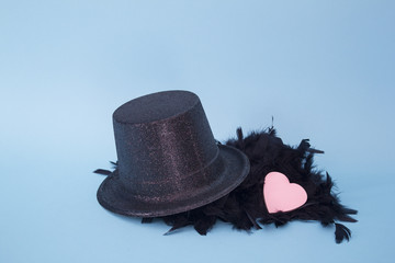 Sombrero con plumas y corazón sobre fondo azul