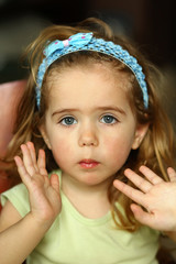Close up portrait of a very emotional toddler girl with an expression of surprise
